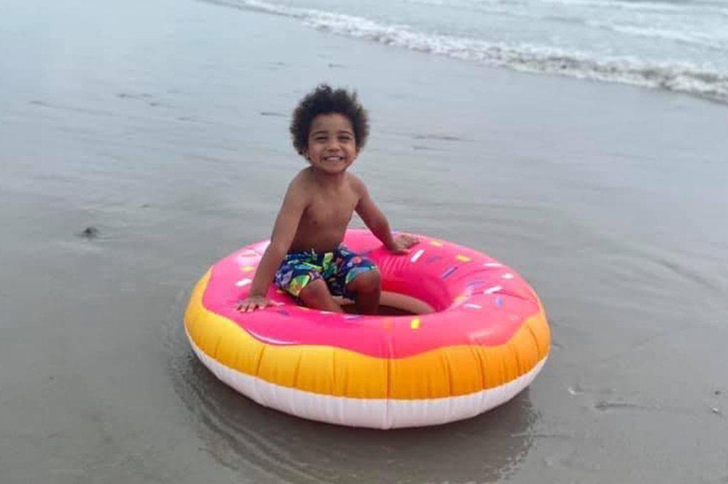 Jaevion Riley at the beach in a floatation device.