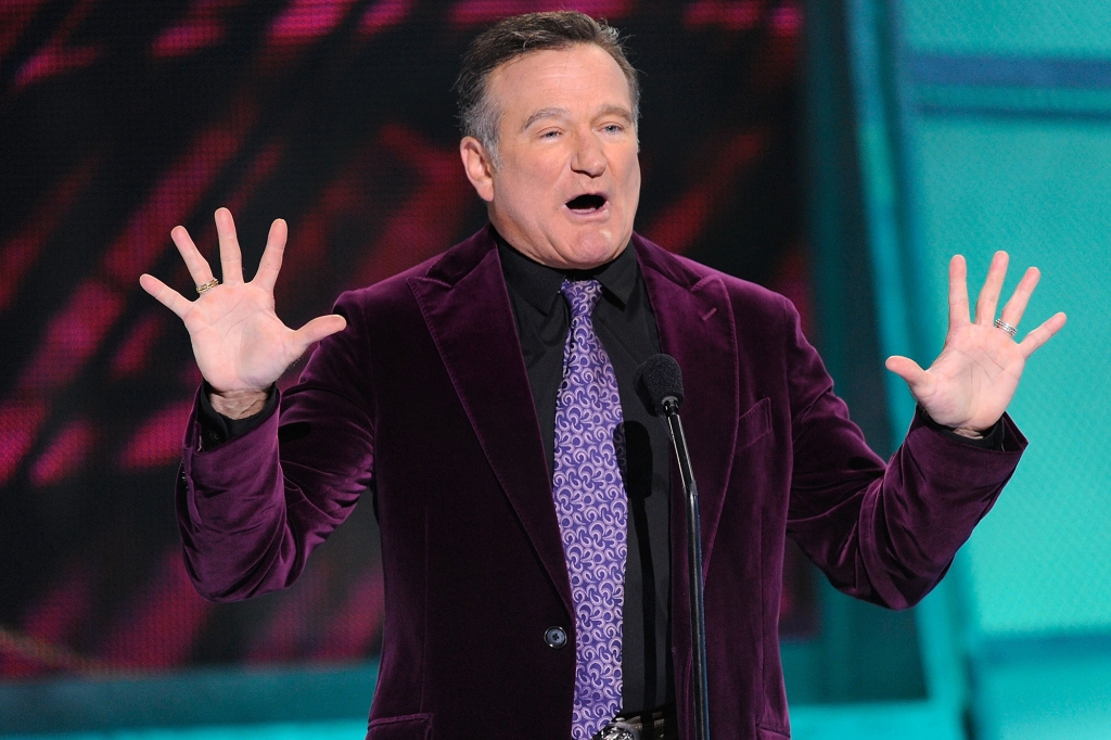Robin Williams onstage in a velvet suit. 