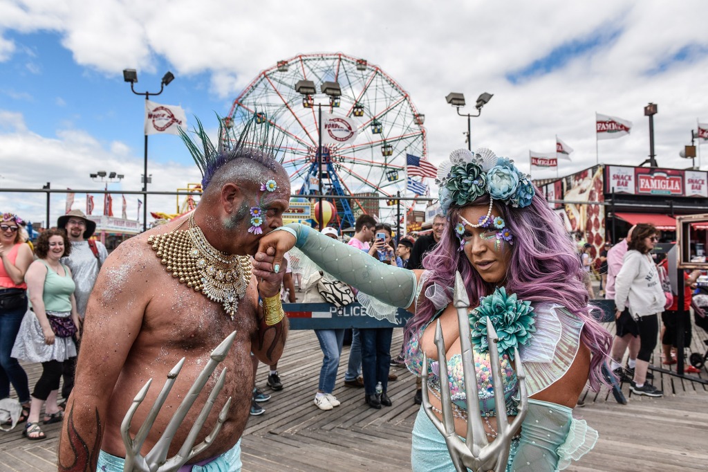 A man kisses his beau’s hand on the Coney Island boardwalk.