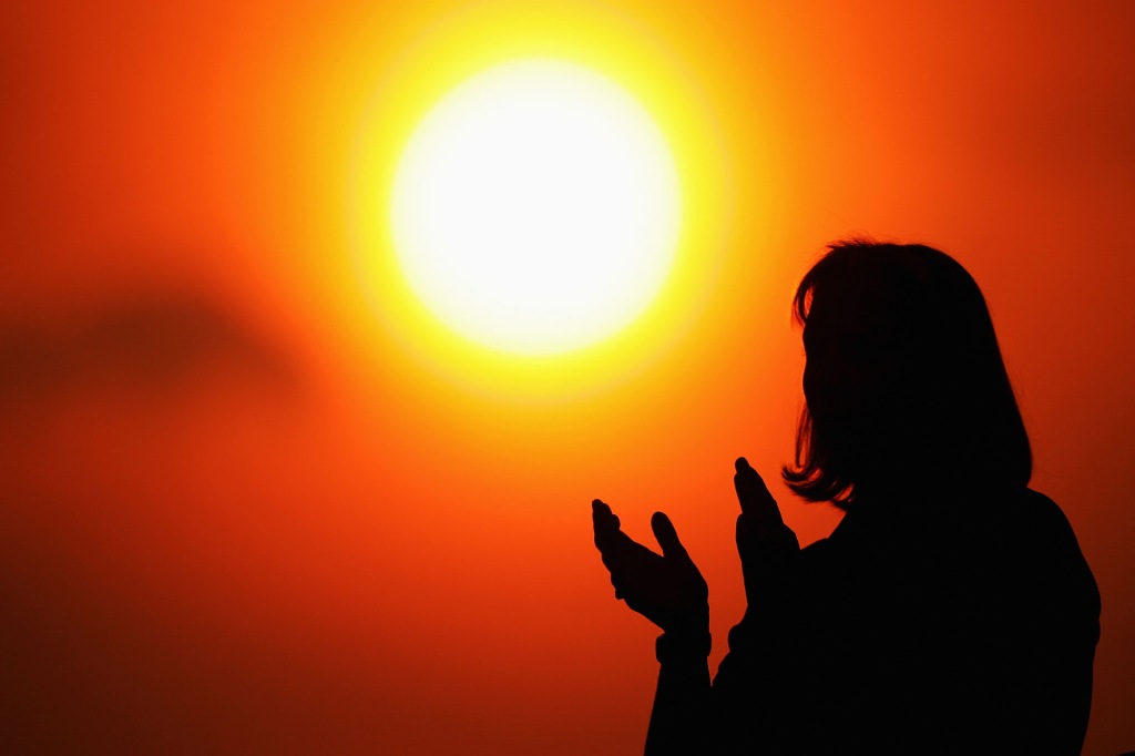 Person clapping at the sun.